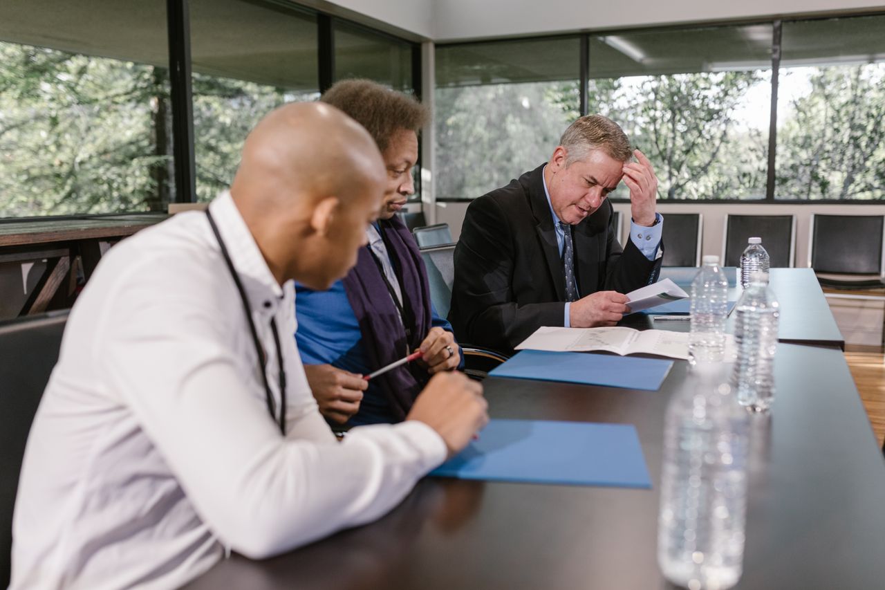 Professionals reviewing documents during a technical advisory meeting